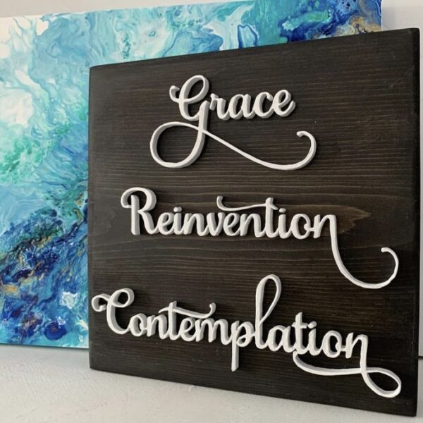 Grace Reinvention and Contemplation cut out in wood